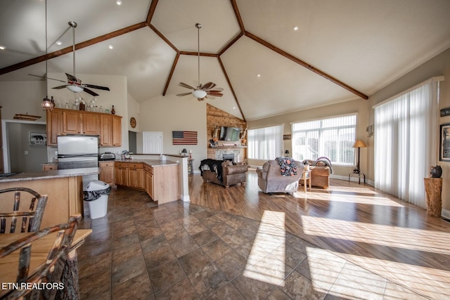 kitchen with a brick fireplace, ceiling fan, dark hardwood / wood-style floors, and high vaulted ceiling