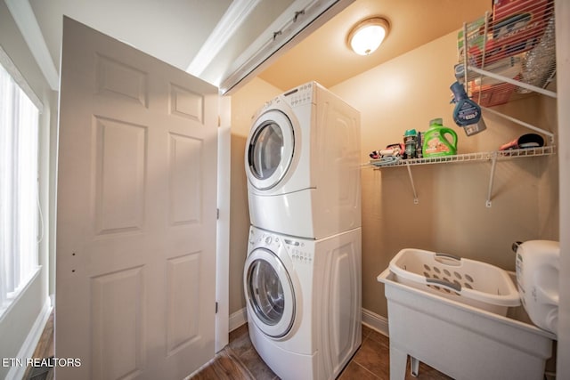 clothes washing area with stacked washer / dryer and dark hardwood / wood-style floors