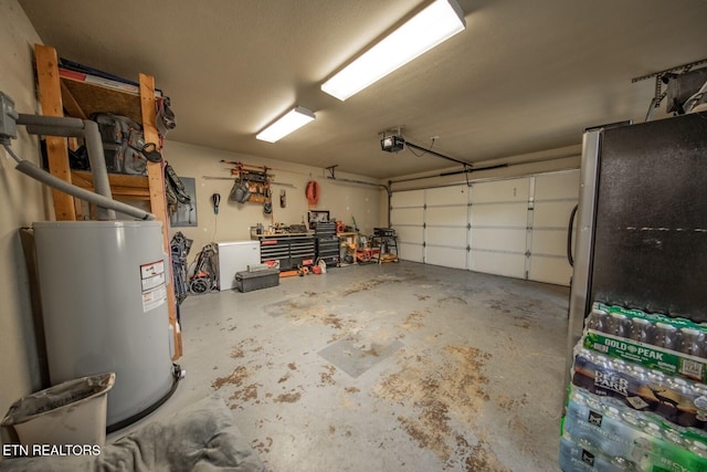 garage featuring water heater, a garage door opener, and stainless steel refrigerator