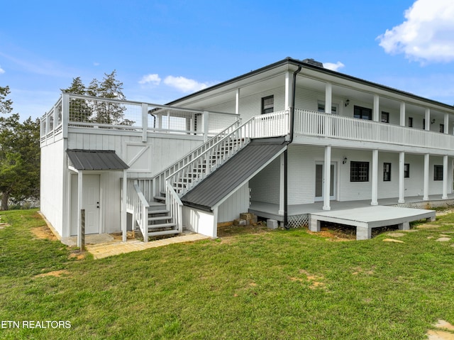 rear view of house featuring a deck and a lawn