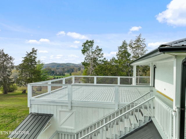 wooden terrace with a mountain view and a yard