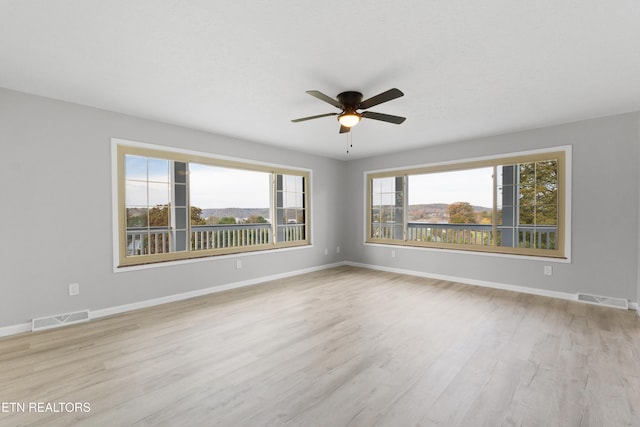 unfurnished room with ceiling fan, light hardwood / wood-style floors, and plenty of natural light