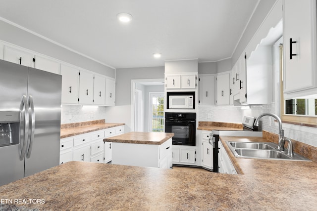 kitchen with a wealth of natural light, backsplash, appliances with stainless steel finishes, and sink