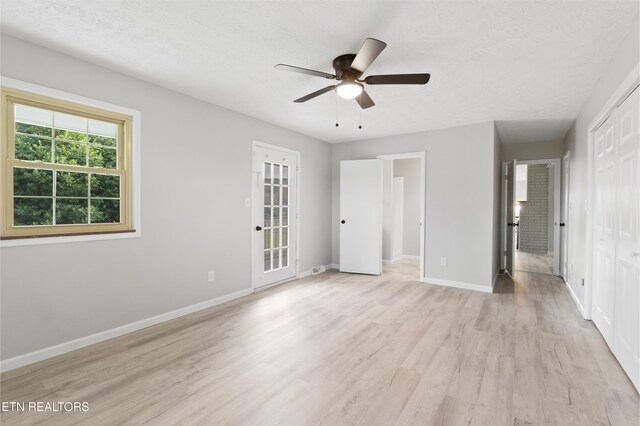 unfurnished bedroom featuring a textured ceiling, light hardwood / wood-style flooring, and ceiling fan