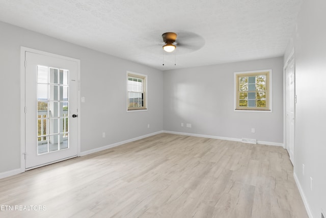 spare room with light hardwood / wood-style flooring, a textured ceiling, and ceiling fan