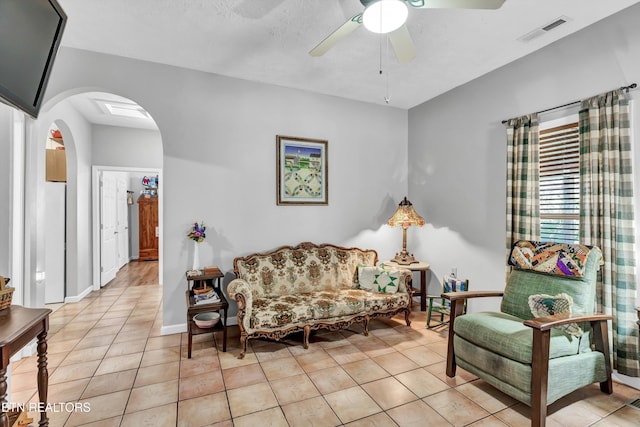 tiled living room featuring ceiling fan