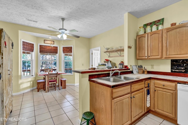 kitchen with kitchen peninsula, white dishwasher, ceiling fan, sink, and light tile patterned floors