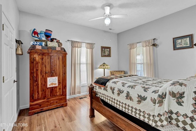 bedroom featuring multiple windows, ceiling fan, and light wood-type flooring