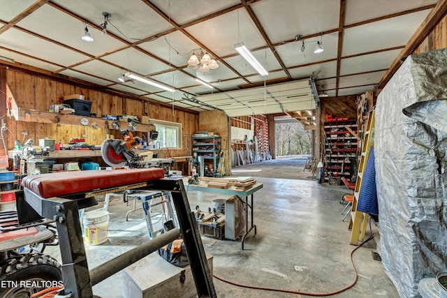 garage with a workshop area and wood walls