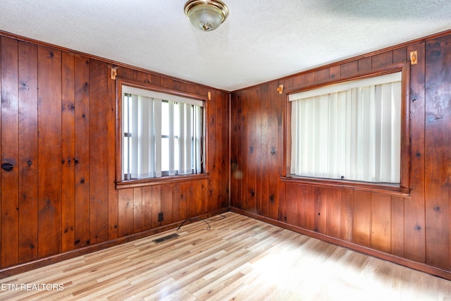 3398 Bell Rd, Sevierville, TN 37862 - unfurnished room with a textured ceiling, wood walls, wood finished floors, and baseboards