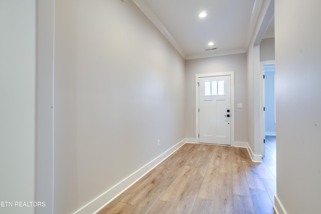 doorway with light hardwood / wood-style flooring and crown molding