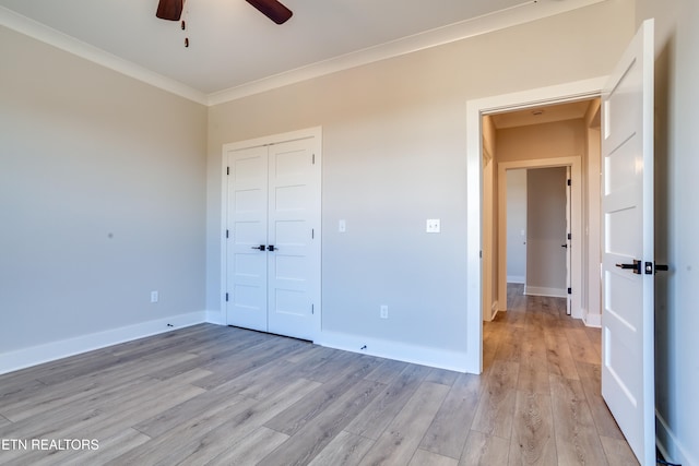 unfurnished bedroom with ornamental molding, a closet, ceiling fan, and light hardwood / wood-style floors