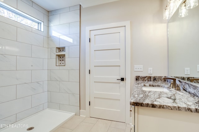 bathroom with vanity, tile patterned flooring, and a tile shower