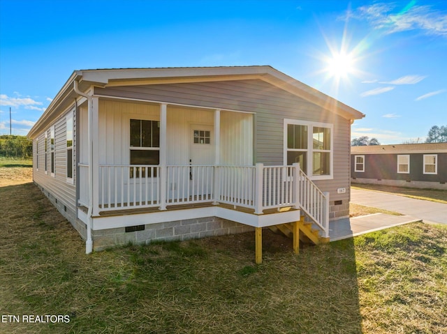 view of front of house with covered porch and a front yard