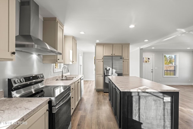 kitchen featuring stainless steel appliances, sink, wall chimney exhaust hood, wood-type flooring, and a kitchen island