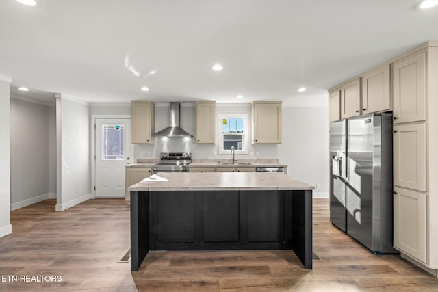 kitchen with light hardwood / wood-style floors, wall chimney exhaust hood, sink, and appliances with stainless steel finishes