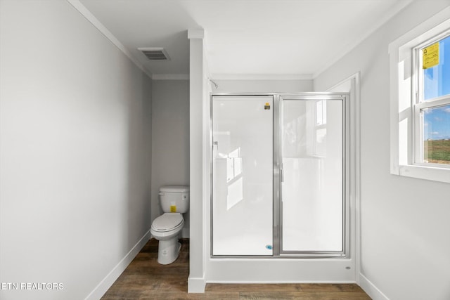 bathroom featuring toilet, wood-type flooring, a shower with door, and crown molding