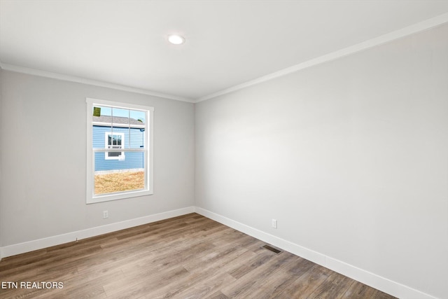 empty room featuring ornamental molding and light hardwood / wood-style floors