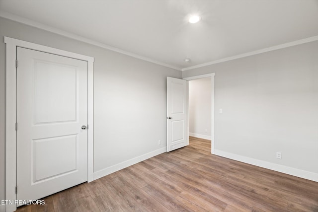 unfurnished bedroom with light wood-type flooring and crown molding