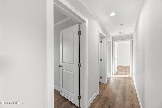 corridor with ornamental molding and dark hardwood / wood-style flooring