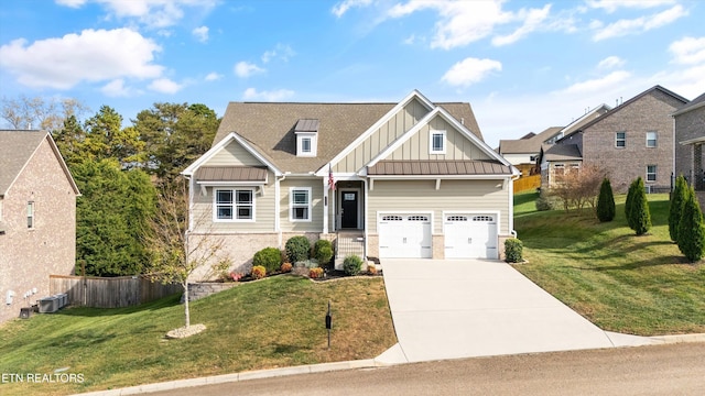 craftsman house with driveway, fence, board and batten siding, a front yard, and a garage