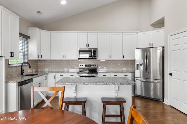 kitchen with a kitchen island, white cabinetry, sink, and stainless steel appliances