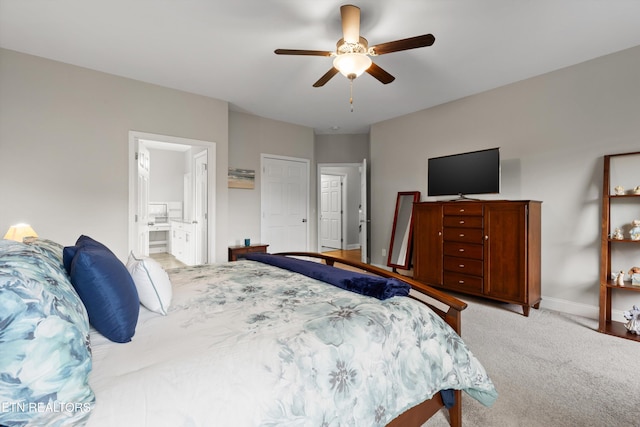 bedroom featuring ensuite bathroom, light colored carpet, and ceiling fan