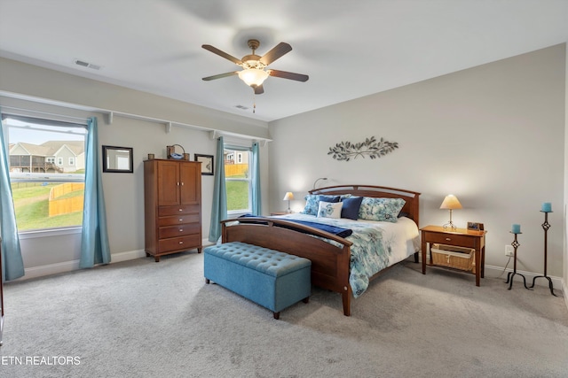 carpeted bedroom with multiple windows and ceiling fan