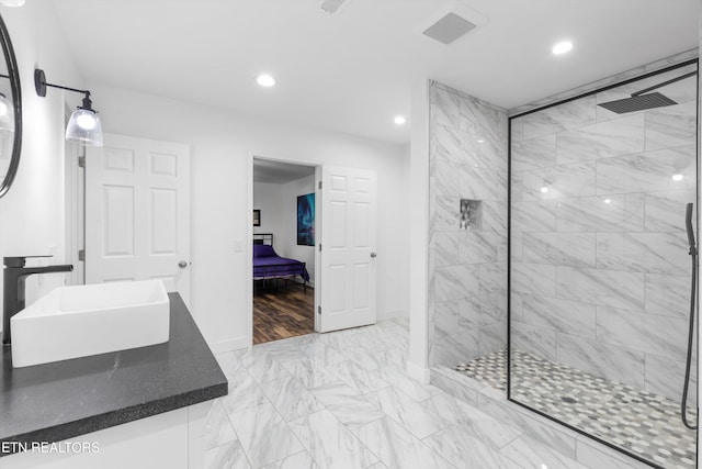 bathroom with vanity and tiled shower