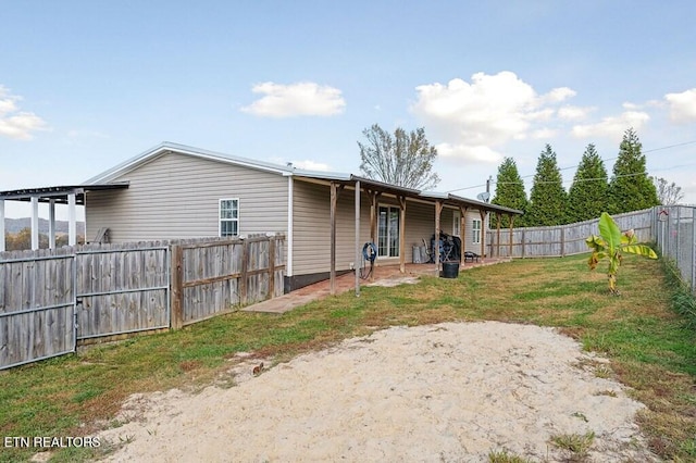 back of house featuring a lawn