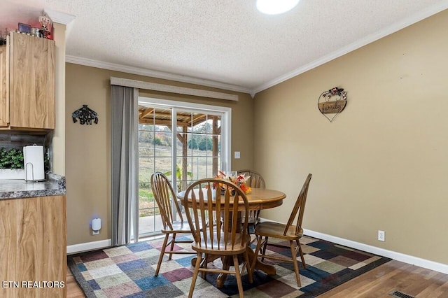 dining space featuring ornamental molding, dark hardwood / wood-style flooring, and a textured ceiling