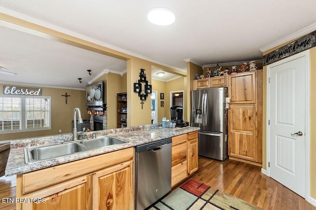 kitchen with stainless steel appliances, sink, a kitchen island, crown molding, and dark wood-type flooring