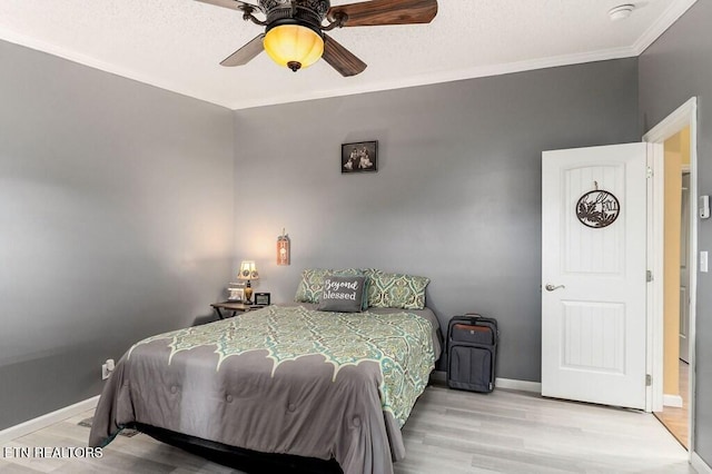 bedroom featuring ornamental molding, ceiling fan, and light hardwood / wood-style floors