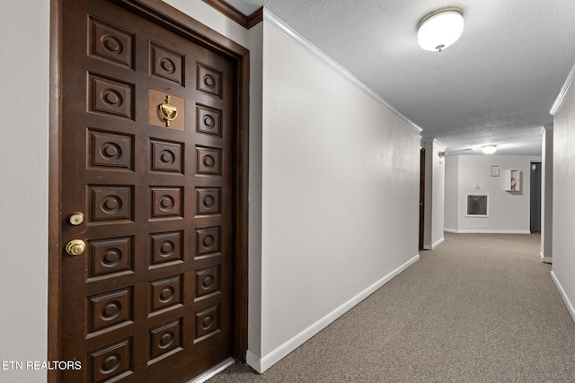 corridor featuring carpet flooring, crown molding, and a textured ceiling