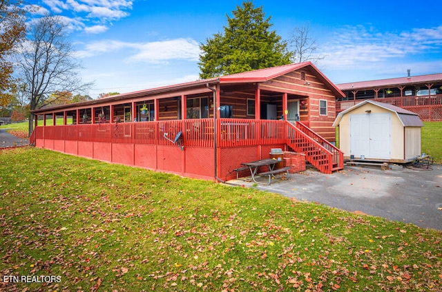 view of front of property featuring a front lawn and a storage unit