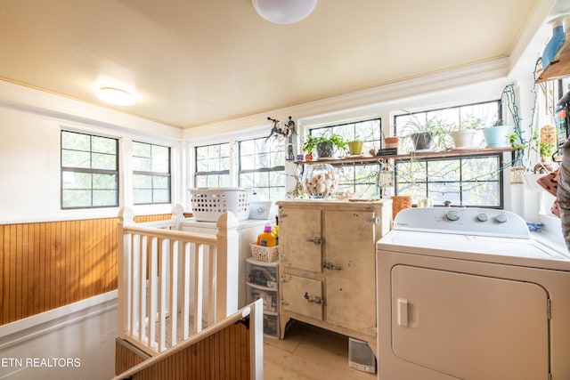 clothes washing area with wood walls and washing machine and dryer