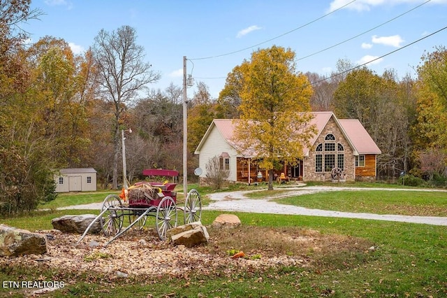 view of front of property featuring a front lawn and a storage unit