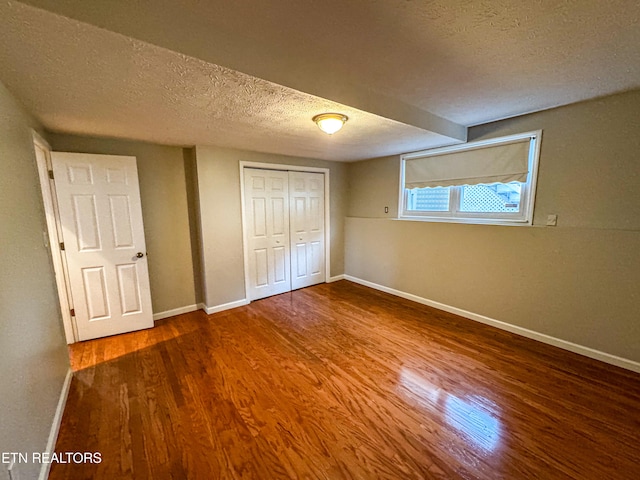 unfurnished bedroom with a closet, a textured ceiling, and hardwood / wood-style flooring