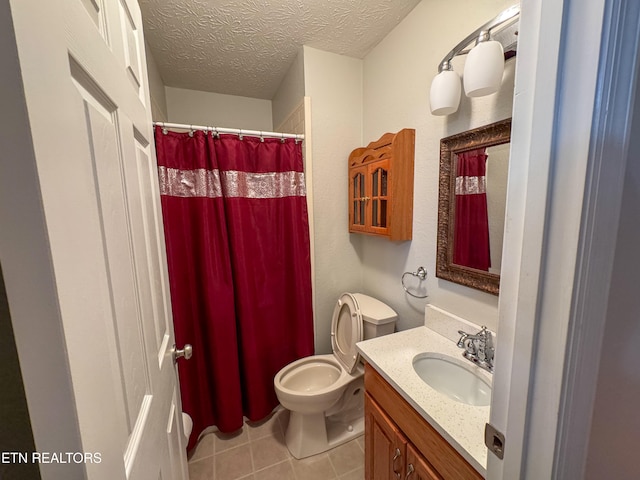 bathroom with toilet, vanity, a textured ceiling, and tile patterned flooring