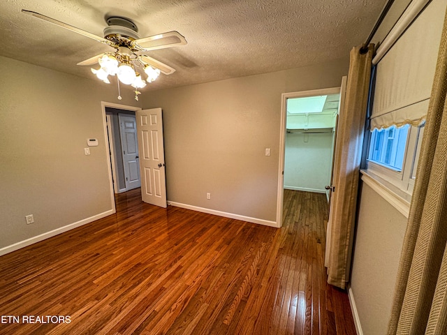 spare room with a textured ceiling, dark hardwood / wood-style floors, and ceiling fan