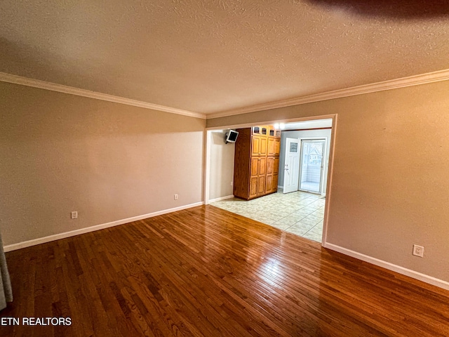 unfurnished room with light hardwood / wood-style floors, a textured ceiling, and crown molding