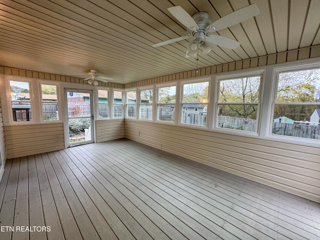 unfurnished sunroom featuring wood ceiling and ceiling fan