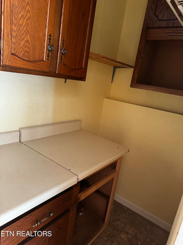 clothes washing area with dark tile patterned floors