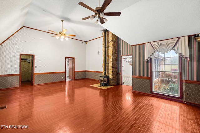 unfurnished living room with a wood stove, hardwood / wood-style flooring, and a textured ceiling