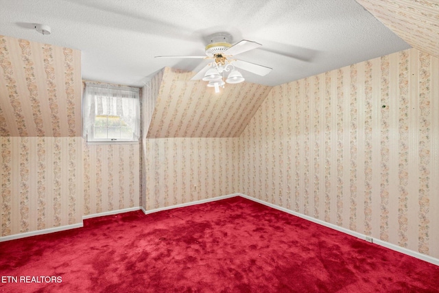 bonus room with carpet, a textured ceiling, vaulted ceiling, and ceiling fan