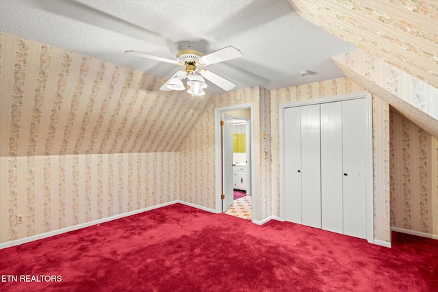 additional living space featuring a textured ceiling, vaulted ceiling, ceiling fan, and carpet floors