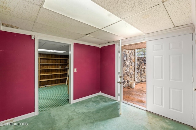 basement with a drop ceiling and carpet