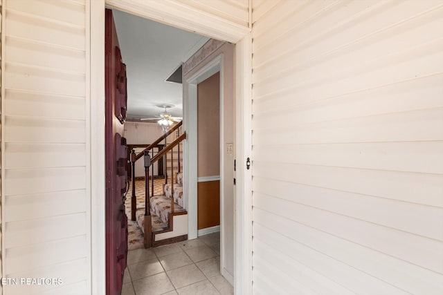 corridor with tile patterned flooring and wooden walls