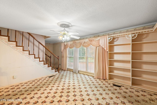 interior space with ceiling fan, a textured ceiling, and carpet floors