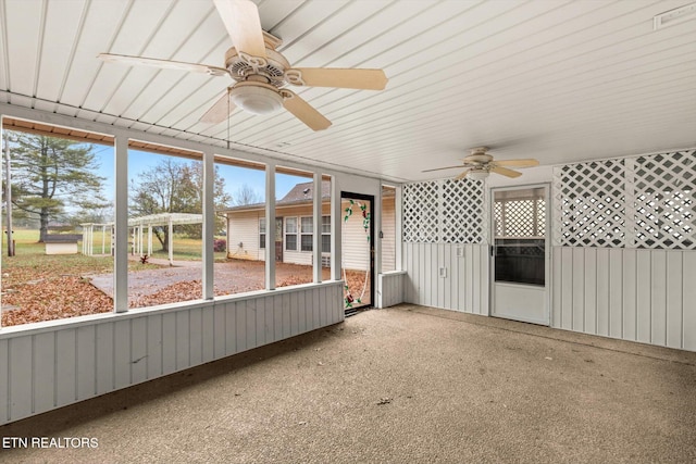 unfurnished sunroom with ceiling fan